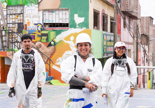 grupo de jóvenes con vestimenta de protección para pintar murales artísticos